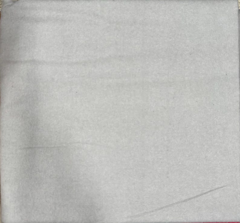 May include: A plain white fabric swatch. The fabric has a slightly textured surface.