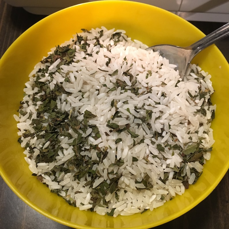 Puede incluir: Un bol amarillo lleno de arroz blanco y hierbas verdes picadas.