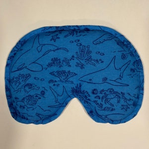 Puede incluir: M&aacute;scara de dormir azul con un patr&oacute;n de tibur&oacute;n y arrecife de coral.