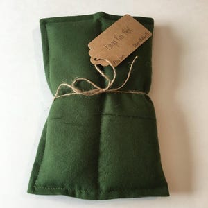 May include: A green fabric heat pack tied with twine and a brown paper tag that reads "Linen Eye Pack" and "Etsy Shop".