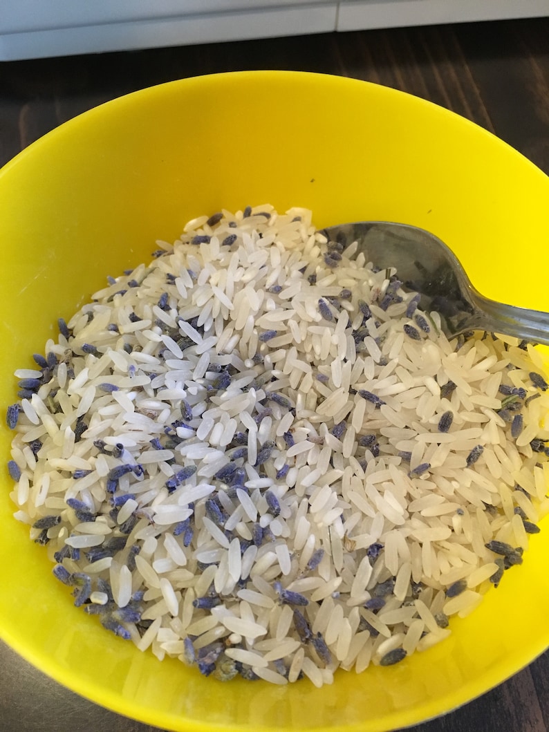 Puede incluir: Un bol amarillo lleno de arroz blanco y flores de lavanda secas.