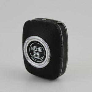 Puede incluir: Un fot&oacute;metro negro con un borde plateado y el texto "ELECTRO BEWI STANDARD Made in Germany".