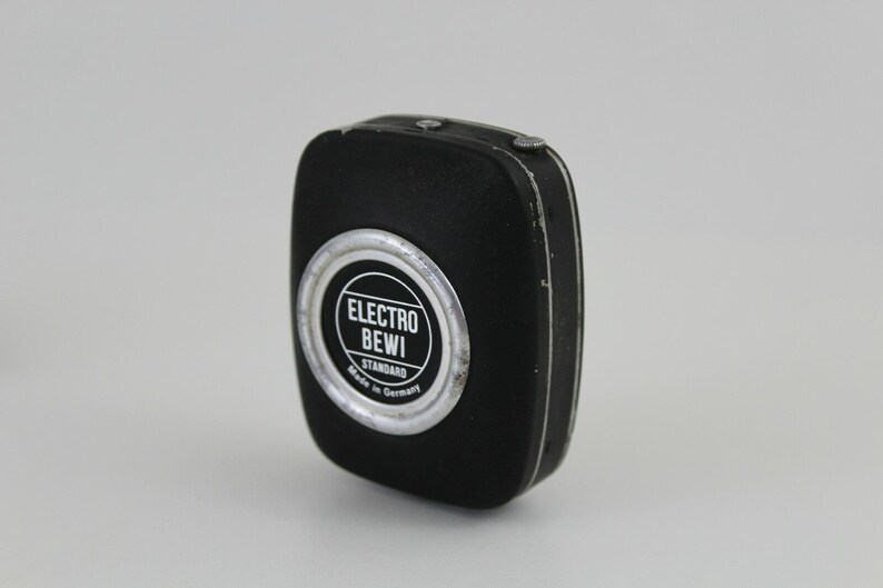 Puede incluir: Un fot&oacute;metro negro con un borde plateado y el texto "ELECTRO BEWI STANDARD Made in Germany".