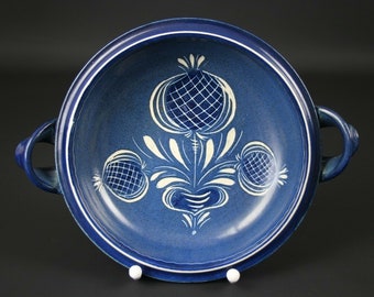 Könnte beinhalten: Eine blaue Keramikschüssel mit zwei Griffen. Die Schüssel hat ein weißes Blumenmuster mit stilisierten Blumen.