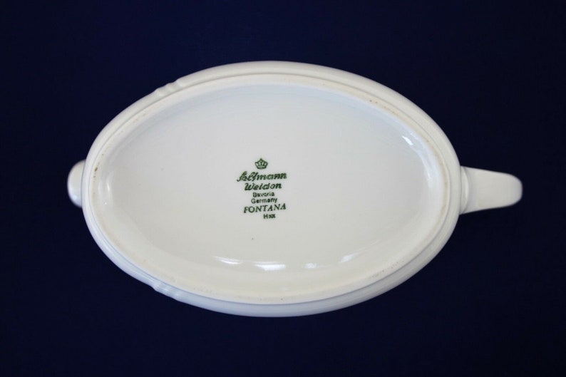 Puede incluir: Cremaera de cer&aacute;mica ovalada blanca con un logotipo verde que dice "Altmann Weiden Bavaria Germany FONTANA 1118"