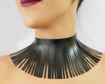 May include: A black leather choker necklace with a fringe design. The fringe is made of thin strips of leather that hang down from the choker.