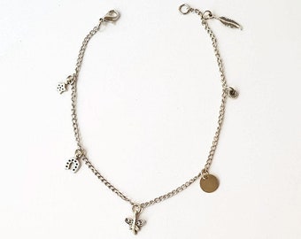 Puede incluir: Pulsera de plata con dijes de herradura, mariposa, pluma y círculo.
