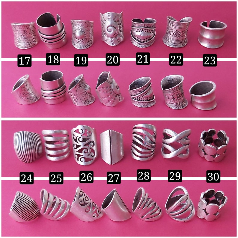 May include: Thirty silver rings with various designs, including geometric, floral, and abstract patterns. The rings are numbered 17 through 30.