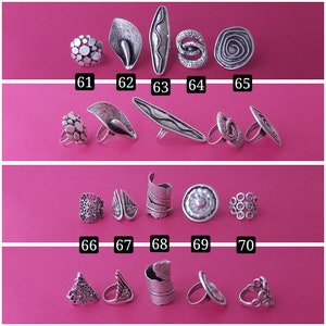 May include: A collection of 10 silver rings with various designs, including floral, geometric, and abstract patterns. The rings are arranged in four rows on a pink background, numbered 61 through 70.