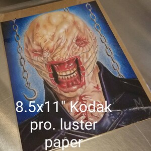 May include: A detailed drawing of a monstrous creature with a stitched-up mouth and chains, printed on 8.5x11" Kodak pro. luster paper.