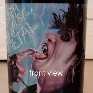 May include: Black coffee mug with a colorful image of a person with black hair and a black leather glove. The person is sticking their tongue out and the image has the words "Death Metal" written in white on a blue background.