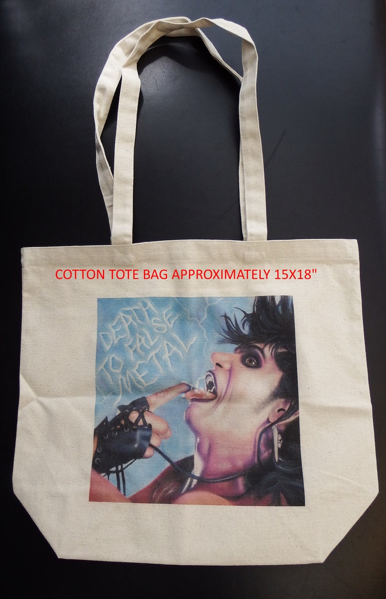 May include: A white cotton tote bag with a graphic print of a person with long black hair and a black leather glove. The graphic is of a person with their tongue sticking out and the text "Death to False Metal" is visible. The bag is approximately 15x18 inches.