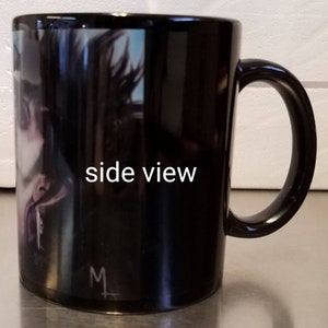 May include: Black ceramic mug with a side view of a person's face on the front. The mug has a white handle and the text "side view" is printed on the side of the mug.