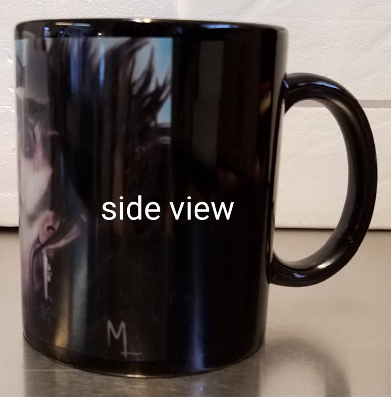 May include: Black ceramic mug with a side view of a person's face on the front. The mug has a white handle and the text "side view" is printed on the side of the mug.