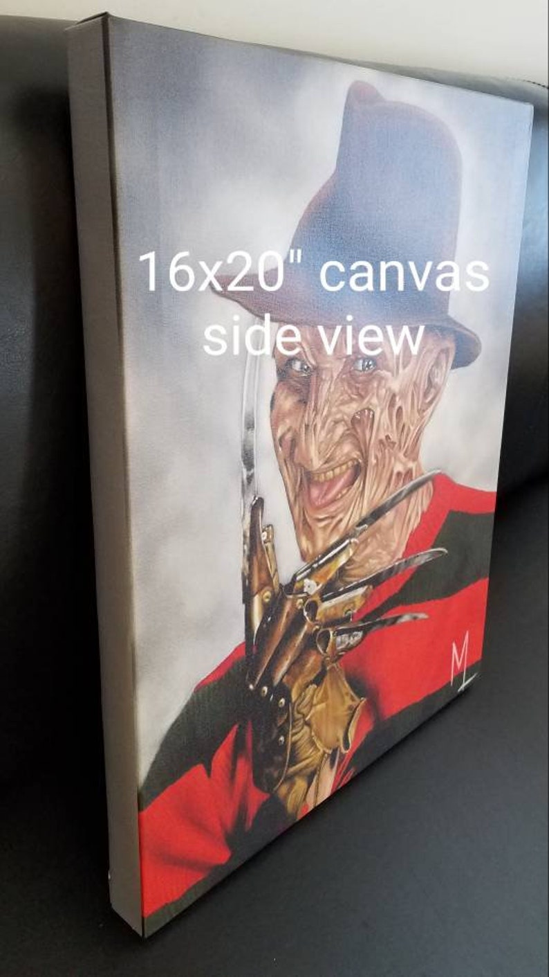 May include: A 16x20 inch canvas painting of Freddy Krueger from the Nightmare on Elm Street movie franchise. He is wearing a red and green striped sweater, a brown fedora hat, and a glove with razor-sharp blades. He has a menacing smile and is looking directly at the viewer.