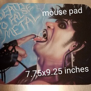May include: A mouse pad featuring a colorful illustration of a person with long black hair, wearing a black leather glove, with the text "Death to False Metal" and "mouse pad" printed on the pad. The pad measures 7.75x9.25 inches.