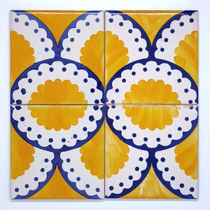 May include: Four square ceramic tiles with a repeating pattern. Each tile features a yellow, fan-shaped design with a white scalloped border and blue accents. The tiles are arranged to create a larger, cohesive pattern.