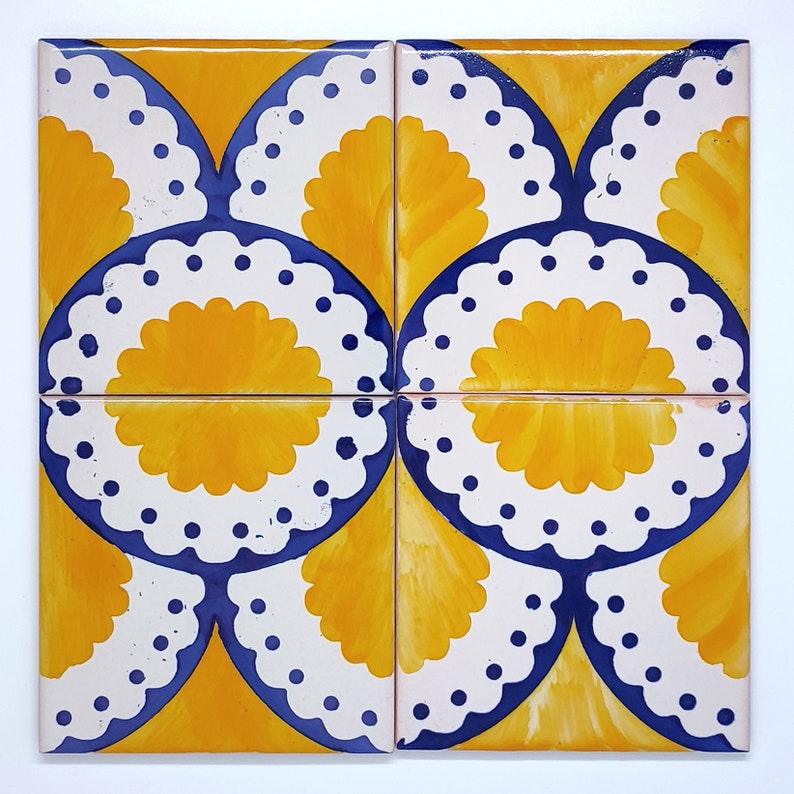 May include: Four square ceramic tiles with a repeating pattern. Each tile features a yellow, fan-shaped design with a white scalloped border and blue accents. The tiles are arranged to create a larger, cohesive pattern.
