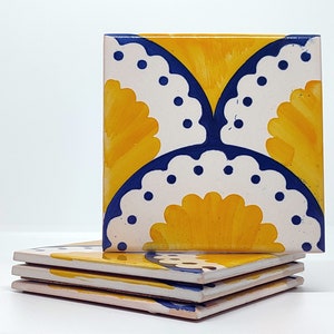 May include: Four square ceramic tiles stacked together. Each tile has a repeating pattern of yellow, white, and blue floral designs. The tiles are hand-painted with a glossy finish, creating a vibrant and colourful aesthetic.