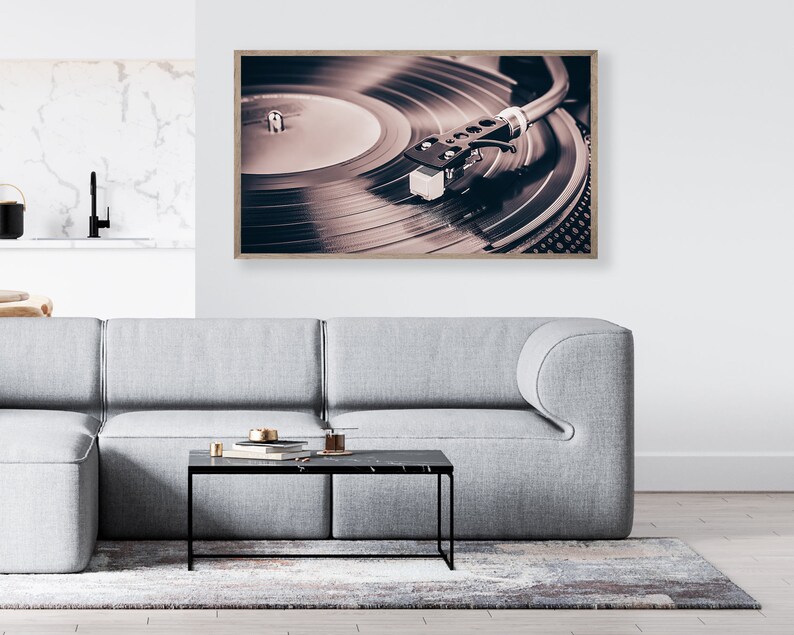 Peut inclure: Une photographie encadr&eacute;e d'un tourne-disque vintage avec un disque vinyle noir tournant sur le plateau. L'aiguille est dans le sillon du disque et le bras de lecture est &eacute;tendu. L'image est en s&eacute;pia.