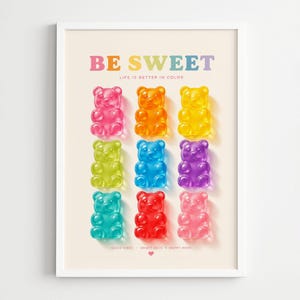 Peut inclure: Une affiche encadrée avec neuf oursons en gélatine colorés disposés en grille. Les oursons sont roses, oranges, jaunes, verts, bleus, violets, turquoise, rouges et rose clair. Le texte "BE SWEET" est en haut, avec "LIFE IS BETTER IN COLOR" en dessous.