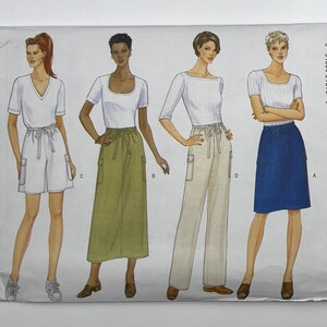 May include: A sewing pattern envelope featuring illustrations of four different garment styles: white shorts, an olive green midi skirt, beige trousers, and a blue knee-length skirt, all paired with white tops and labeled with letters A, B, C, and D.