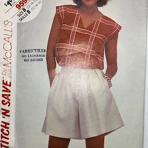 May include: A sewing pattern envelope by McCall's labeled Stitch 'N Save, featuring a model wearing a rust-colored V-neck top with a white grid pattern and solid white shorts. The envelope includes text indicating size B, 12-14-16, and Fabricville.