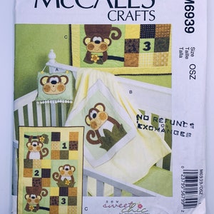 May include: McCall's Crafts sewing pattern M6939 for a monkey-themed baby set, including a quilt, pillow, and blanket. The pattern provides instructions for a patchwork quilt with monkey appliqués, a matching pillow, and a blanket. Designed by Susan Cousineau.