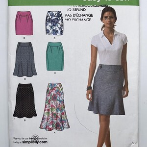 May include: Simplicity sewing pattern 2451 for skirts in sizes P5 12, 14, 16, 18, 20. The envelope displays illustrations of six skirt variations including solid pink, blue floral, grey, teal, black polka dot, and multi-colored floral patterns.