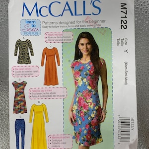 Op de afbeelding: McCall's naaipatroon M7122 voor beginners. De afbeelding toont een vrouw in een bloemenjurk, met illustraties van verschillende jurkstijlen. Bevat instructies en basis naaitips.