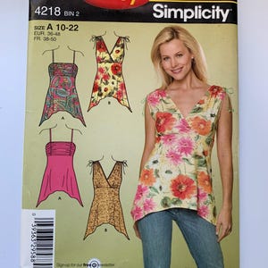 Pode incluir: Um padrão de costura para uma blusa feminina com decote em V e um laço nos ombros. O padrão é da Simplicity e é do tamanho 10-22. O padrão inclui instruções para fazer uma blusa com estampa paisley, estampa floral e estampa de leopardo.