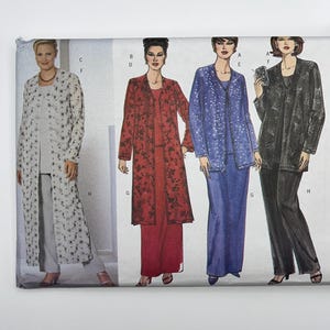 May include: A sewing pattern envelope featuring illustrations of four different outfits, each consisting of a long-sleeved jacket worn over a top and trousers or a skirt. The designs include a white floral set, a red floral set, a blue patterned set, and a black set.