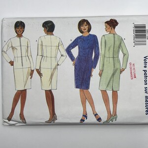 May include: A sewing pattern envelope featuring illustrations of two dress styles. Style A is a cream-colored long-sleeved dress with a front zipper. Style B is a blue patterned dress and a light green dress, both with long sleeves and back zippers.