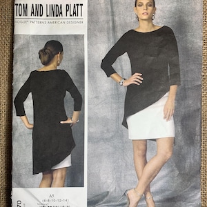 Op de afbeelding: Een naaipatroonpakket met een vrouw in een zwarte top en witte rok. Het pakket heeft de tekst "TOM AND LINDA PLATT" en "VOGUE PATTERNS AMERICAN DESIGNER". Het patroonnummer is V1470, maat A5 (6-8-10-12-14).