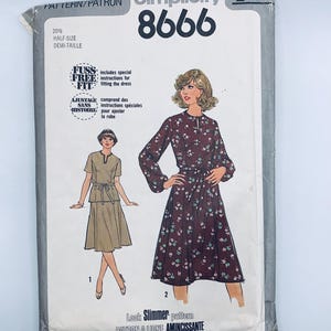 May include: Simplicity sewing pattern number 8666 for a dress. The pattern includes instructions for a "fuss free fit" and a "slimmer look" pattern. The pattern is for a half-size dress.