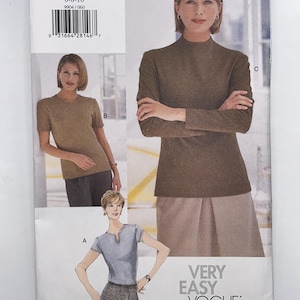 May include: A Very Easy Vogue sewing pattern envelope 9904 for sizes 6-8-10. The front displays three garment variations: a light blue short-sleeve top with a notched neckline, a tan short-sleeve crew neck top, and a brown long-sleeve mock neck top.