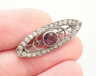 Spilla antica in argento massiccio con pasta di ametista, stile vittoriano, con decorazioni a grappolo di pasta di diamanti a forma di occhio ed ellisse, risalente al XIX secolo. Autentico gioiello vintage da donna.
