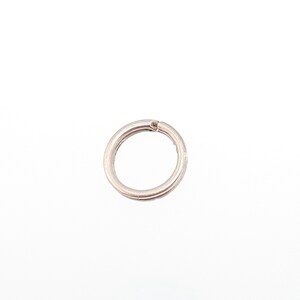 May include: A silver split ring, a small metal ring with a split, used for attaching keys or other items. The ring is circular and has a double-loop design. The background is plain white.