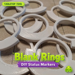 May include: White plastic blank rings for tabletop games. The rings are in a crescent shape with a flat base. The text "TABLETOP TOOL" is at the top, and "Blank Rings" and "DIY Status Markers" are at the bottom.