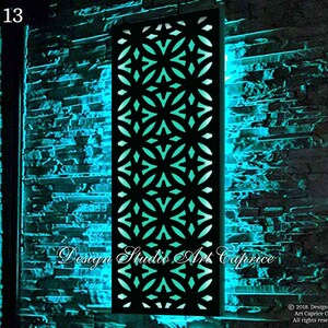 May include: A rectangular black metal wall panel featuring a repeating geometric pattern of intersecting circles and four-pointed stars, backlit with a vibrant cyan light. The panel displays the text Design Studio Art Caprice.