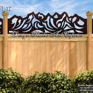 May include: A brown metal fence topper with a mountain range design. The topper is attached to a wooden fence. The text "FT-17" and "Design Studio Art Caprice" are visible in the image.
