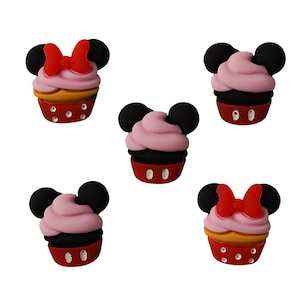 May include: Five cupcake-shaped charms with Mickey Mouse ears. Two charms have pink frosting and a red bow, and three charms have pink frosting and black ears.