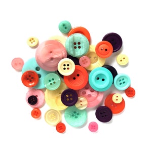 Op de afbeelding: Assortiment van kleurrijke knopen in verschillende vormen en maten. De knopen zijn gemaakt van plastic en hebben een gladde, glanzende afwerking. De kleuren omvatten rood, oranje, geel, groen, blauw, paars, roze en wit.