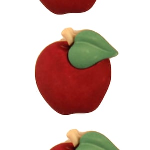 May include: Three red felt apples with green felt leaves. The apples are arranged vertically.