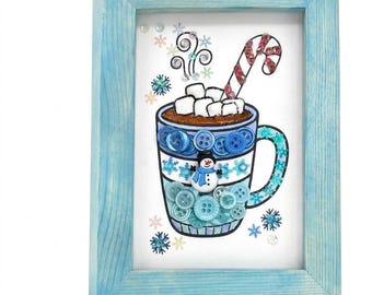May include: A framed artwork featuring a whimsical illustration of a hot chocolate mug. The mug is adorned with blue buttons and a snowman, topped with marshmallows and a candy cane. The frame is painted light blue.