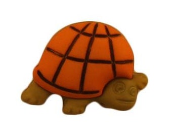 May include: Orange and brown plastic turtle button with a grid pattern on the shell.