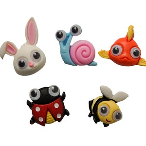 May include: Five colorful plastic animal figurines with googly eyes. The animals are a rabbit, snail, fish, ladybug, and bee.