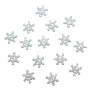 May include: A collection of iridescent snowflake-shaped buttons. Each button is white with a glittery finish and has six points. The buttons have four holes for sewing and are scattered across a white background.