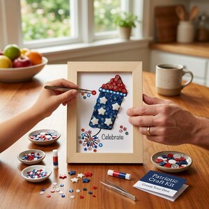 May include: A framed patriotic craft kit featuring a firework design made of red, white, and blue buttons and star-shaped embellishments. The word "Celebrate" is written below the firework. Includes small bowls of buttons and a "Patriotic Craft Kit" card.