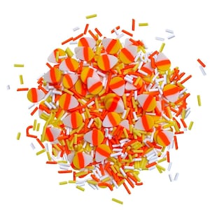 May include: A mix of orange, yellow and white candy sprinkles in the shape of candy corn. The sprinkles are scattered on a white background.